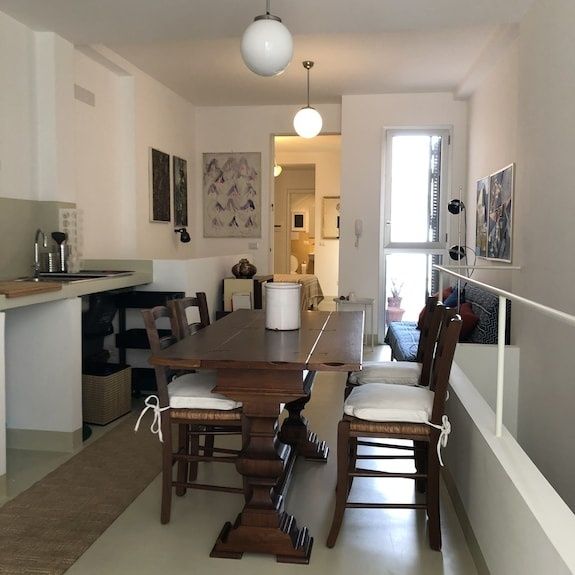 Salle à manger d’appartement avec tableaux et éclairage naturel
